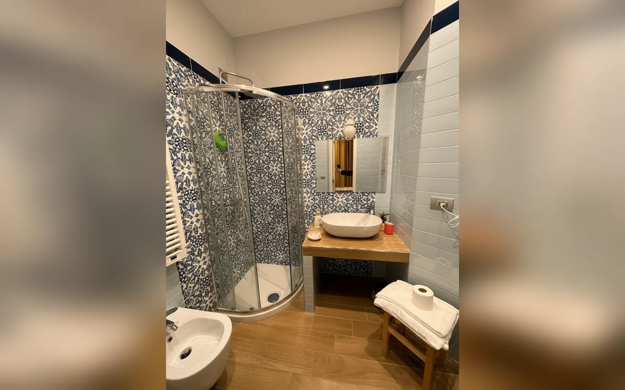 Bagno privato con doccia e rivestimenti in maiolica