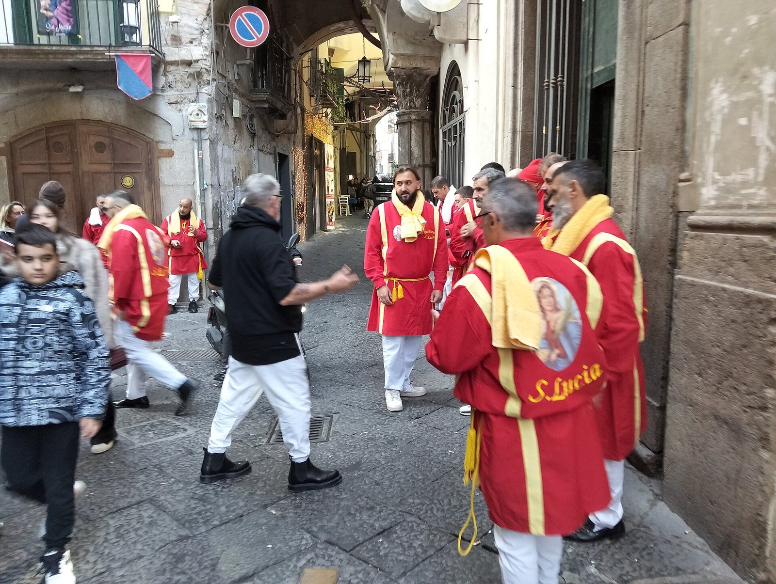 Confratelli in abito rosso durante una processione nel centro di Salerno